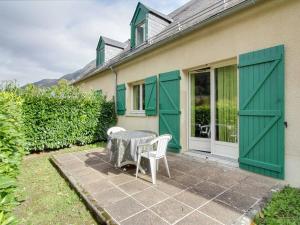 un patio con tavolo e sedie di fronte a una casa di Chalet mitoyen 3 chambres, 60m², belle vue, 1km centre-ville, navette ski, parking, terrasse - FR-1-401-3 a Cauterets