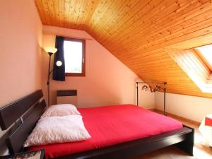 a bedroom with a red bed in a attic at Appartement La Salle-les-Alpes, 3 pièces, 7 personnes - FR-1-330F-22 in Serre Chevalier