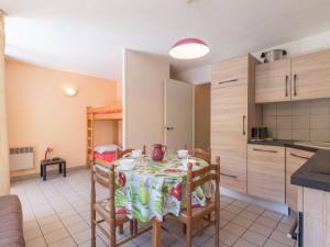 Appartement Briançon, 1 pièce, 4 personnes - FR-1-330C-49 في بريانسو: مطبخ مع طاولة وكراسي في غرفة