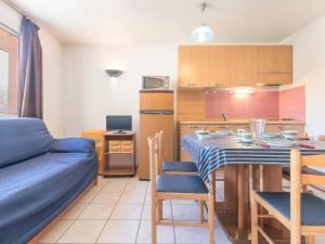 sala de estar y cocina con mesa y sofá azul en Appartement Briançon, 2 pièces, 5 personnes - FR-1-330C-22 en Briançon