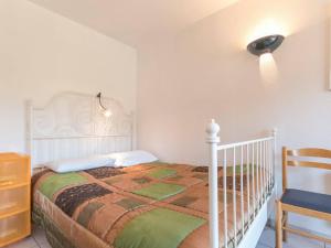 1 dormitorio con 1 cama con cuna y silla en Appartement Briançon, 2 pièces, 5 personnes - FR-1-330C-22 en Briançon