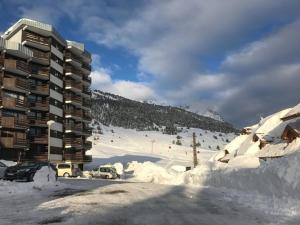 un parcheggio coperto di neve di fronte a un edificio di Studio Montgenèvre, 1 pièce, 4 personnes - FR-1-266-102 a Monginevro