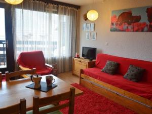 ein Wohnzimmer mit einem roten Sofa und einem Tisch in der Unterkunft Studio Montgenèvre, 1 pièce, 4 personnes - FR-1-266-102 in Montgenèvre