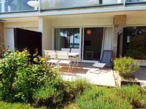 une terrasse avec 2 chaises et une table sur une maison dans l'établissement Appartement La Trinité-sur-Mer, 2 pièces, 4 personnes - FR-1-477-34, à La Trinité-sur-Mer