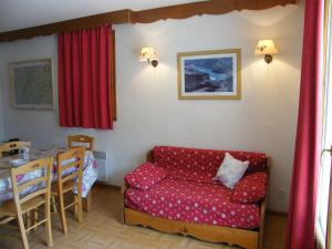 ein Wohnzimmer mit einem roten Sofa und einem Tisch in der Unterkunft Appartement Puy-Saint-Vincent, 2 pièces, 6 personnes - FR-1-330G-95 in Puy-Saint-Vincent
