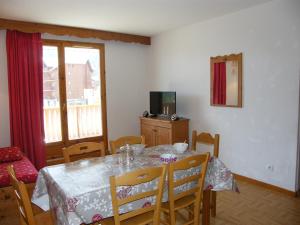 ein Esszimmer mit einem Tisch, Stühlen und einem TV in der Unterkunft Appartement Puy-Saint-Vincent, 2 pièces, 6 personnes - FR-1-330G-95 in Puy-Saint-Vincent
