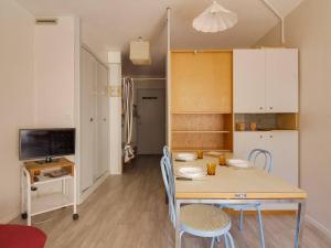 a kitchen and dining room with a table and chairs at Charmant studio à Cauterets avec balcon, parking couvert et proche télécabine - FR-1-401-24 in Cauterets