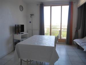 a white table and chairs in a room with a window at Studio Argelès-sur-Mer, 1 pièce, 3 personnes - FR-1-388-60 in Argelès-sur-Mer