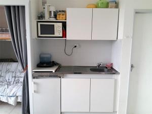 a small kitchen with a sink and a microwave at Studio Argelès-sur-Mer, 1 pièce, 3 personnes - FR-1-388-60 in Argelès-sur-Mer
