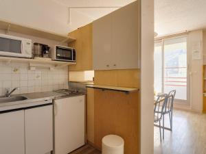 a small kitchen with a sink and a microwave at Charmant studio à Cauterets avec balcon, parking couvert et proche télécabine - FR-1-401-24 in Cauterets