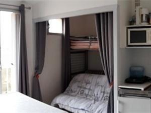 een kleine slaapkamer met een bed in een kamer bij Studio Argelès-sur-Mer, 1 pièce, 3 personnes - FR-1-388-60 in Argelès-sur-Mer