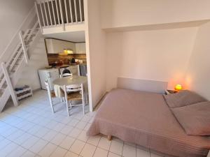1 dormitorio con cama, mesa y cocina en Studio Argelès-sur-Mer, 1 pièce, 4 personnes - FR-1-388-91, en Argelès-sur-Mer