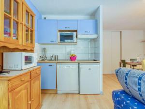 uma cozinha com electrodomésticos brancos e armários de madeira em Appartement Barèges, 2 pièces, 6 personnes - FR-1-403-17 em Barèges