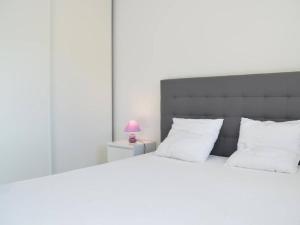 a bedroom with a large white bed with a pink lamp at Appartement moderne 2 chambres avec terrasse, parking et climatisation à Banyuls-sur-Mer - FR-1-225C-531 in Banyuls-sur-Mer