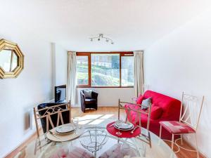 uma sala de estar com um sofá vermelho e uma mesa de vidro em Appartement La Mongie, 2 pièces, 6 personnes - FR-1-404-47 em La Mongie