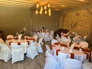 a room full of tables and chairs with white tablecloths at Le Domaine des Crouquets in Jayac
