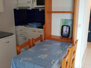 a small kitchen with a table with a blue table cloth at Argelès-sur-Mer, T2 + Cabine, 6 pers., plage à 100m, parking, ascenseur - FR-1-388-19 in Argelès-sur-Mer +3 photos