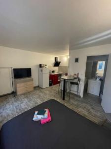 sala de estar con mesa y cocina en Superbe appartement terrasse wifi, en Paroy-sur-Tholon