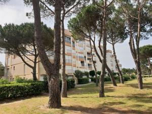 uma fila de árvores em frente a um edifício em Appartement Argelès-sur-Mer, 2 pièces, 4 personnes - FR-1-388-31 em Argelès-sur-Mer