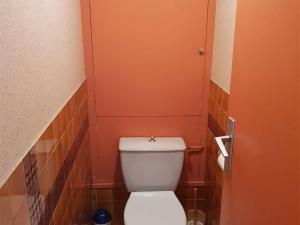 a bathroom with a toilet with an orange door at Appartement Argelès-sur-Mer, 2 pièces, 4 personnes - FR-1-388-31 in Argelès-sur-Mer