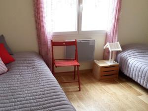 スーストンにあるVilla Soustons, 5 pièces, 8 personnes - FR-1-379-79のベッドルーム1室(ベッド2台、窓際の赤い椅子付)