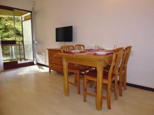 une salle à manger avec une table et des chaises en bois dans l'établissement Charmant Studio à Proximité des Pistes – 4 Pers., Balcon, Tout Équipé - FR-1-400-4, à Gourette
