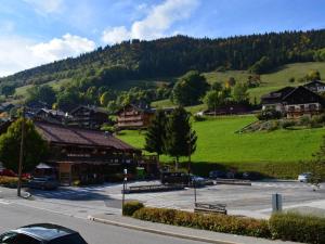 een klein stadje met een groene heuvel op de achtergrond bij Appartement Le Grand-Bornand, 1 pièce, 4 personnes - FR-1-241-185 in Le Grand-Bornand