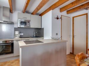 una cucina con mobili bianchi e un piano di lavoro di Chalet en duplex à Cauterets, 2 chambres, 7 pers., terrasse, près des remontées, parking inclus - FR-1-401-6 a Cauterets