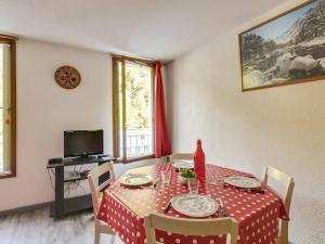 uma sala de jantar com uma mesa com uma toalha de mesa vermelha e branca em Studio Barèges, 1 pièce, 6 personnes - FR-1-403-12 em Barèges