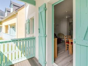 uma varanda com uma porta azul e uma mesa em Maison Cauterets, 3 pièces, 5 personnes - FR-1-401-39 em Cauterets