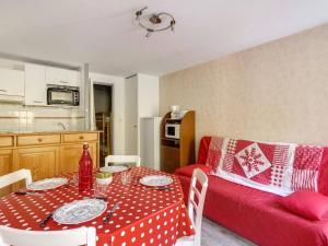 Una sala de estar con una mesa y un sofá rojo. en Studio cabine 6 pers, idéal montagne, ascenseur, ski, parking, animaux admis - FR-1-403-12, en Barèges 4 fotos más