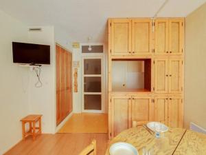 - une salle à manger avec une table et une télévision dans la chambre dans l'établissement Studio 4 pers avec balcon, centre-ville, proche télécabine, idéal famille – Cauterets - FR-1-401-53, à Cauterets