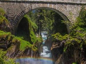 a stone bridge over a river with a rainbow at Cauterets : Appartement cosy 4 pers, centre-ville, proche télécabine, parking ski inclus. - FR-1-401-16 in Cauterets +3 photos
