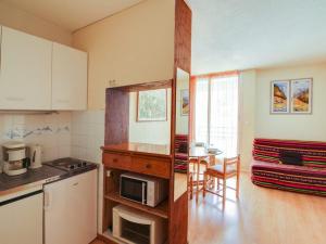une cuisine avec un comptoir et une table avec un micro-ondes dans l'établissement Studio 4 pers avec balcon, centre-ville, proche télécabine, idéal famille – Cauterets - FR-1-401-53, à Cauterets