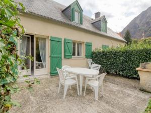 un patio con tavolo e sedie di fronte a una casa di Chalet 3 chambres avec terrasse à Cauterets pour 6 personnes - FR-1-401-21 a Cauterets