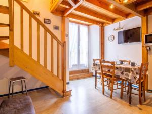 a dining room with a staircase and a table and chairs at Appartement cosy 4 pers avec parking, terrasse, local à skis - FR-1-403-21 in Barèges