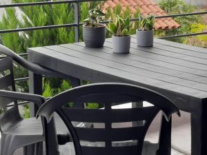 a wooden table and chairs with potted plants on a balcony at Two bedroom modern apartment in Komotini