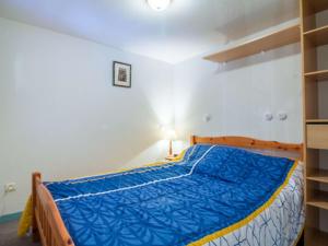 a bedroom with a blue bed in a room at Appartement cosy 4 pers avec parking, terrasse, local à skis - FR-1-403-21 in Barèges