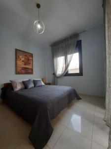 1 dormitorio con cama y ventana en Two bedroom modern apartment, en Komotiní