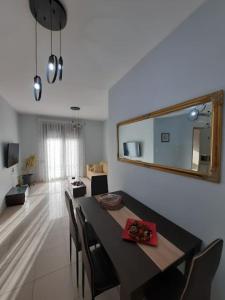 a dining room with a table with chairs and a mirror at Two bedroom modern apartment in Komotini