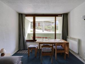 um quarto com uma mesa com cadeiras e uma janela em Studio La Mongie, 1 pièce, 5 personnes - FR-1-404-105 em La Mongie