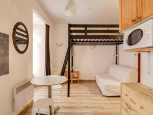 コトレにあるAppartement Cauterets, 3 pièces, 6 personnes - FR-1-401-33の二段ベッド1組、テーブルが備わる小さなアパートメントです。