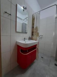 a bathroom with a red sink and a mirror at Two bedroom modern apartment in Komotini