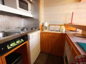 uma pequena cozinha com um lavatório e um fogão em Appartement Peisey-Vallandry, 2 pièces, 6 personnes - FR-1-411-83 em Landry