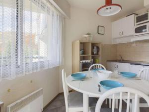 a kitchen with a white table and chairs in a kitchen at Studio Gourette, 1 pièce, 4 personnes - FR-1-400-49 in Gourette