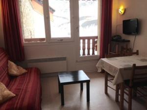 een kamer met een bed, een tafel en een raam bij Studio La Mongie, 2 pièces, 6 personnes - FR-1-404-111 in La Mongie
