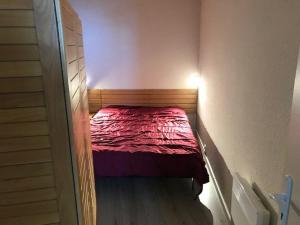 a small bedroom with a red bed in a room at Appartement 6 pers., 1 ch. avec balcon. 100m des pistes! - FR-1-404-122 in La Mongie
