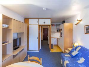 eine kleine Wohnung mit einem blauen Sofa und einer Küche in der Unterkunft Studio lumineux pour 6 personnes près des pistes et des commerces - FR-1-400-63 in Gourette