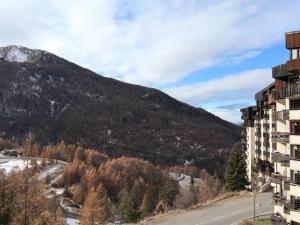 a building with a mountain in the background at Studio Les Orres, 1 pièce, 2 personnes - FR-1-322-307 in Les Orres