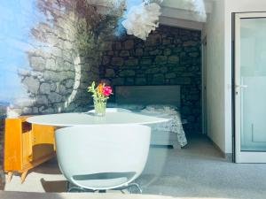 a white table with a vase of flowers on it at LA CASETTA SULLE NUVOLE PETRA in Cammarata